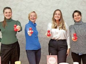 Mitarbeitende von The Future Living halten Spielfiguren des Resilienz-Spiels